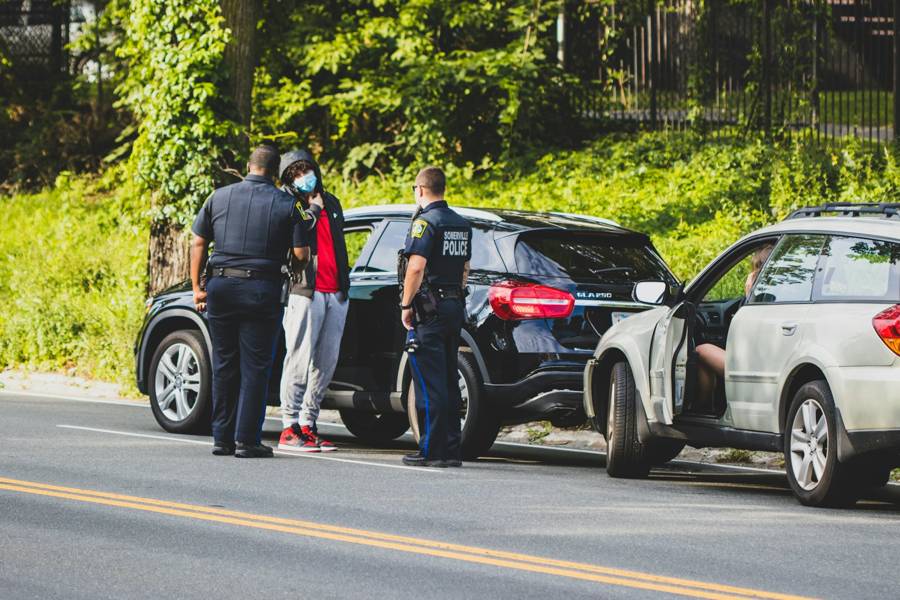Police officers talking with a driver at the scene of a collision