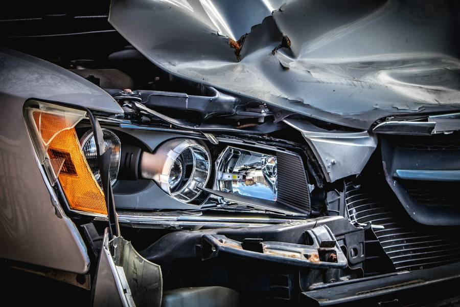 Close view of a crushed hood and broken headlight